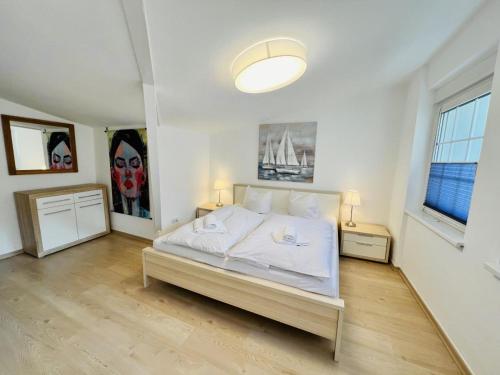 a white bedroom with a bed and a large window at Ferienwohnung beach, ca 150 m zum Strand in Warnemünde