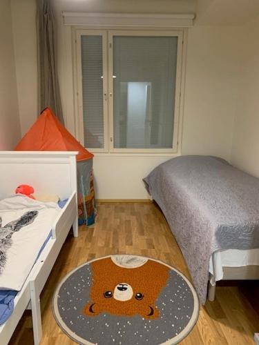 ein Schlafzimmer mit einem Bett und einem runden Teppich auf dem Boden in der Unterkunft Uusi kolmio in Oulu