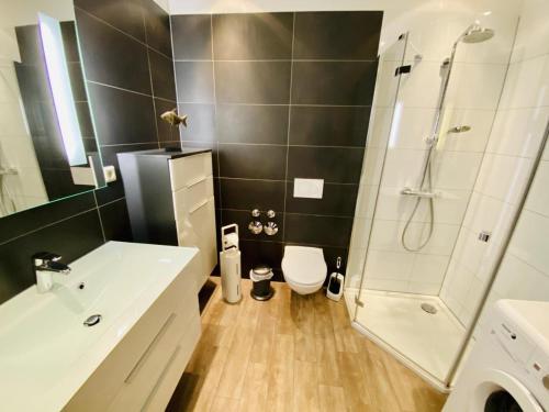 a bathroom with a shower and a toilet and a sink at Berringer, Backbord, direkt an der Promenade in Warnemünde