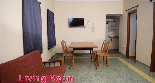 - un salon avec une table, des chaises et un canapé dans l'établissement MOHAN'S RESIDENCY, à Madurai