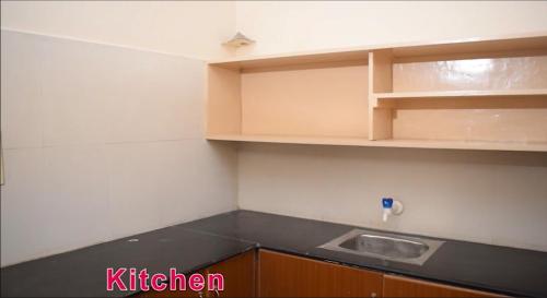 a kitchen with a counter top and a sink at MOHAN'S RESIDENCY in Madurai