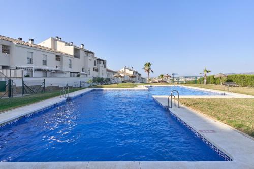 a pool with blue water in front of a building at Apartamento Baviera Golf 002 in Vélez-Málaga