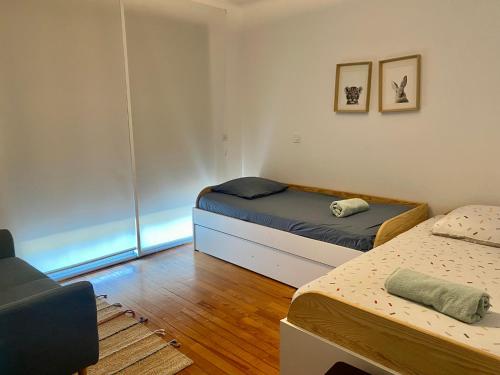 Habitación pequeña con 2 camas y sofá en La villa Garonne avec piscine en Toulouse