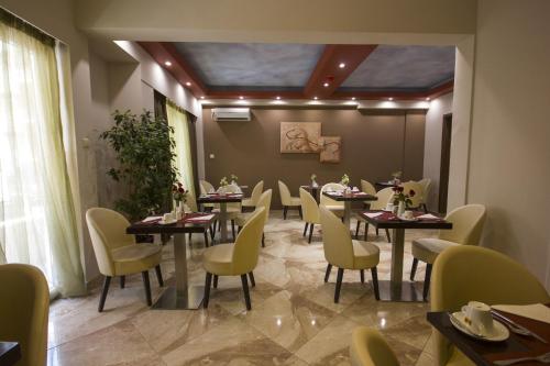 a dining room with tables and yellow chairs at Ambrosia Suites in Athens