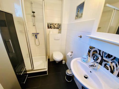 a bathroom with a sink and a shower and a toilet at Ferienhaus Ostseeperle in Warnemünde