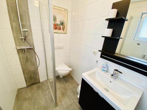uma casa de banho com um chuveiro, um lavatório e um WC. em Ferienhaus Schotstek em Warnemünde