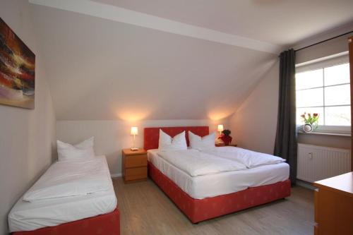 1 Schlafzimmer mit 2 Betten mit weißer Bettwäsche und einem Fenster in der Unterkunft Ferienhaus am Yachthafen, Duenenzauber in Warnemünde