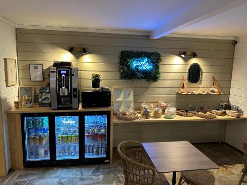 a drink station with a drink cooler and a table at Ostal Pau Universite - Sure Hotel Collection by Best Western in Pau