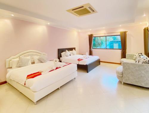 una habitación de hotel con dos camas y un sofá en Sunny2 Villa Pattaya, en Ban Huai Yai