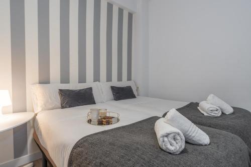 a bedroom with two beds with towels and a candle at tuGuest Pedro Antonio Apartment in Granada