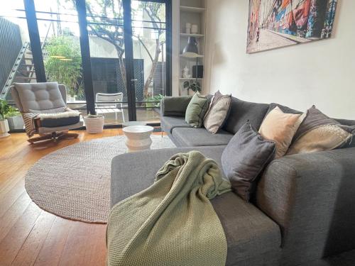 a living room with a couch and a rug at TWO FIVE ZERO RICHMOND four bedroom cityviews lockup garage in Melbourne