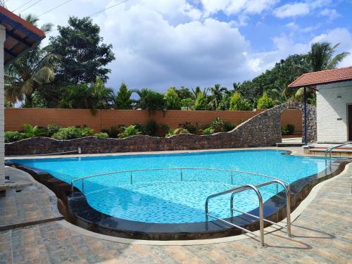 una gran piscina de agua azul en Nirvana Club Resort and Spa, en Bangalore