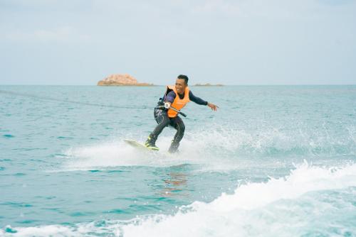 a man riding a wave on a surfboard in the water at Banyu Biru Villa in Lagoi