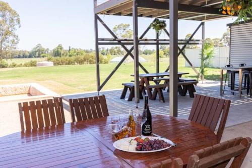 a table with a plate of food and a bottle of wine at Pitt Town Ferry Park in Wilberforce