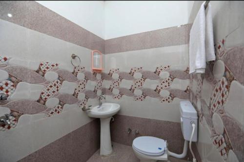 a bathroom with a toilet and a sink at King Palace in Agra