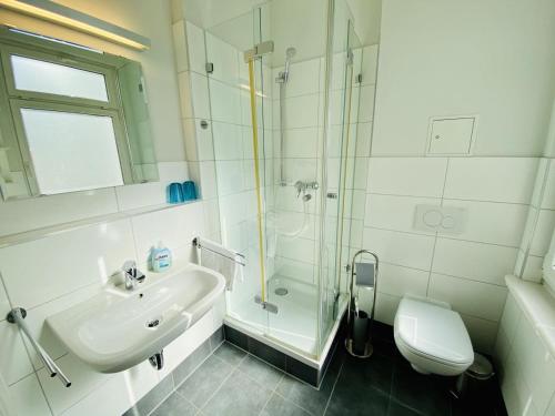 ein Bad mit einem Waschbecken, einer Dusche und einem WC in der Unterkunft Haus Jantzen/Arkona in Warnemünde