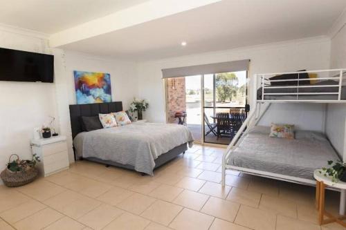 a large bedroom with a bed and a balcony at Pitt Town Ferry Park in Wilberforce