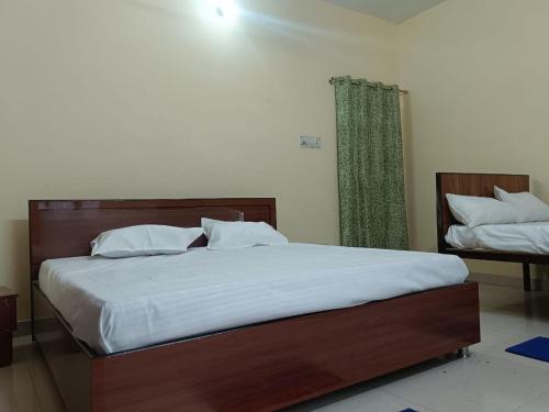 a bedroom with a large bed with white sheets at Shri Gayatri homestay in Ayodhya