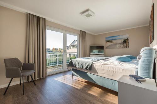 a bedroom with a bed and a desk and a window at Haus Leuchtfeuer/Eagle in Warnemünde