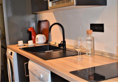 a kitchen counter with a sink and a wine glass at Peralta Villas Boutique Adults Only in Renau