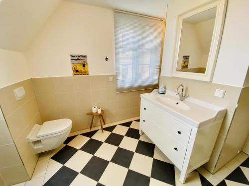 ein Badezimmer mit einem weißen WC und einem Waschbecken in der Unterkunft Haus Milena/Jule in Warnemünde
