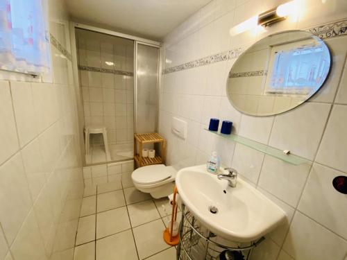 a bathroom with a toilet and a sink and a mirror at Haus Stromblick, Zimmer am Strom in Warnemünde