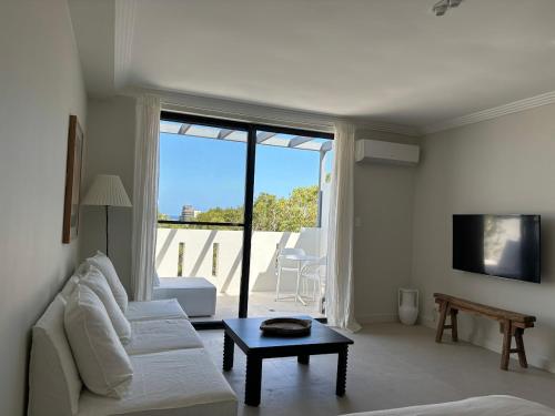 a living room with a white couch and a table at Newly Renovated Sunny Studio - 5min Walk to Beach in Sydney