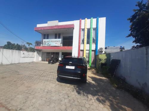 um carro estacionado em frente a um edifício em Turu Hostel em Lampung