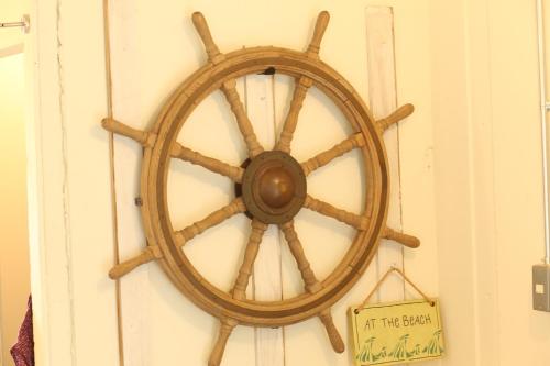 an old wooden steering wheel hanging on a wall at Seaside Harbor Odawara シーサイド ハーバー 小田原 in Odawara