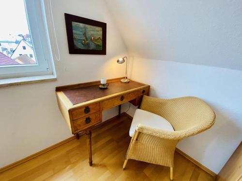 - un bureau et une chaise dans la chambre dans l'établissement Kapitänshaus Möwenblick, à Warnemünde