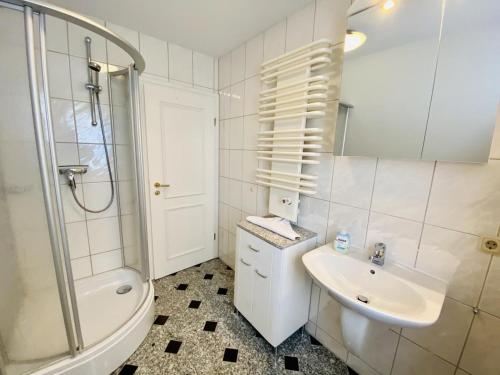 La salle de bains est pourvue d'un lavabo, de toilettes et d'une douche. dans l'établissement Kapitänshaus Möwenblick, à Warnemünde