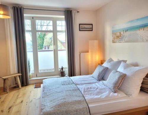 um quarto com uma cama grande e uma janela grande em Kaethchen em Warnemünde