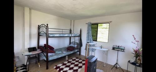 Zimmer mit 2 Etagenbetten und einem Tisch in der Unterkunft DOC AZENITH PRESIDENTIAL SUITE in Pagadian