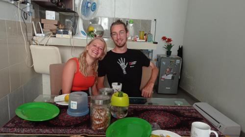 a man and a woman standing in a kitchen at Neny's Homestay in Saba
