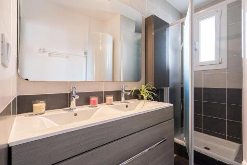 W łazience znajduje się umywalka i lustro. w obiekcie ARES - Vue Mer w mieście Le Grau-dʼAgde