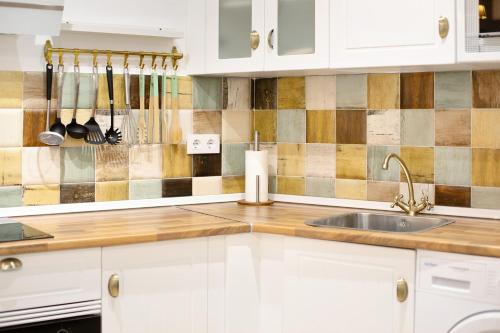 a kitchen with white cabinets and a sink at Casa Olga in Rota