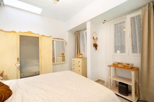 a bedroom with a bed and a dresser and windows at Casa Olga in Rota