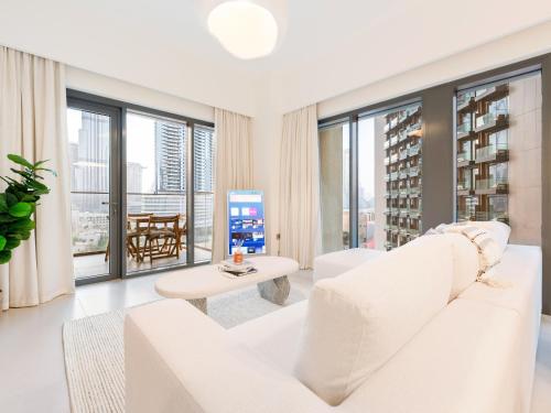 a living room with a white couch and large windows at Lavishly Elegant 2BR with Breathtaking Full Burj Khalifa View in Dubai