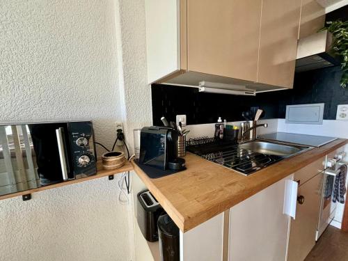 a kitchen with a sink and a counter top at Vue imprenable sur les Alpes et Parking privé gratuit in Crans-Montana