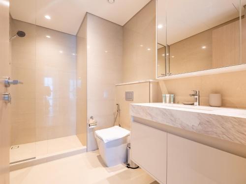 a bathroom with a toilet and a shower and a sink at Lavishly Elegant 2BR with Breathtaking Full Burj Khalifa View in Dubai