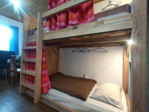 a wooden bunk bed in a room with a ladder at Holiday House Ryukyu-an "MUSIC HOSTEL" in Yomitan