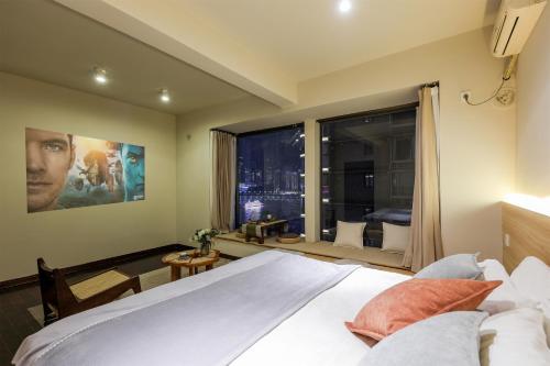a bedroom with a bed and a large window at Baihong Riverview Apartment-Hongya Cave in Chongqing