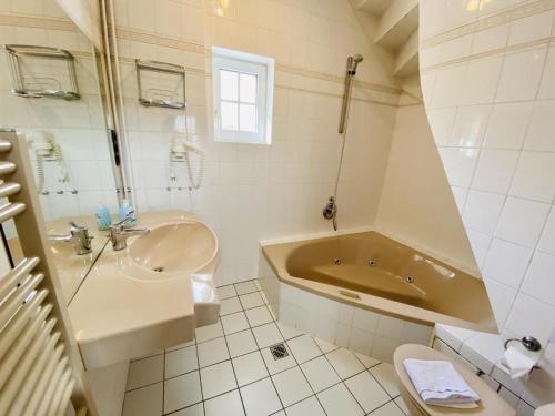 a bathroom with a tub and a sink and a toilet at Fewo Leuchtturm, ca 200m z. Strand in Warnemünde