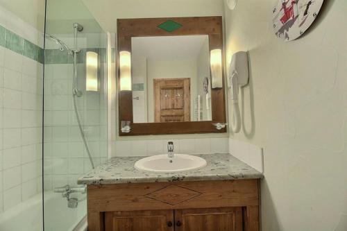 bagno con lavandino, doccia e specchio di ARC 1950 - VUE MONTBLANC & LES ALPES ITALIENNE - Sauna, Hammam, Jacuzzi ad Arc 1950