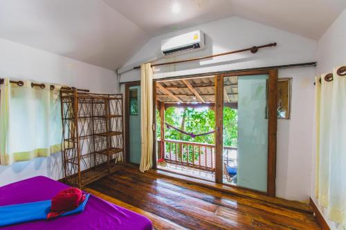 a room with a bed and a window with a balcony at White Beach Bungalows in Koh Rong Island