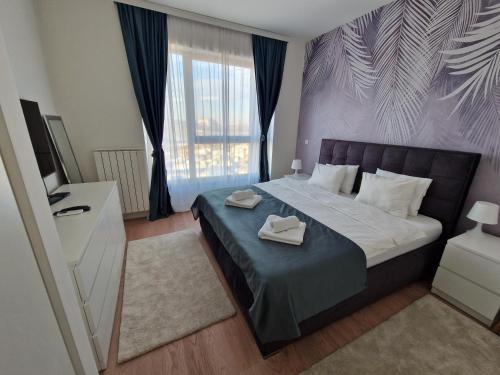 een slaapkamer met een bed met twee handdoeken erop bij Aqua Royal BW apartment in Sajmište