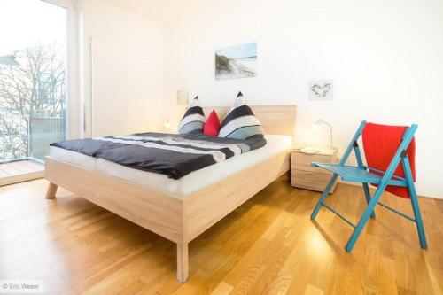 Residenz/Arne في فارنمونده: غرفة نوم بسرير وكرسي ازرق