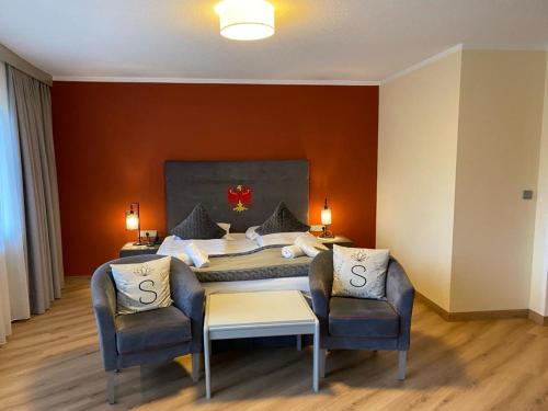 a bedroom with a large bed with two chairs at Garni Das SONNALP in Maurach