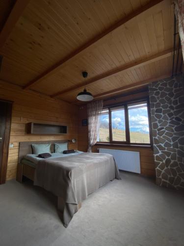 a bedroom with a large bed in a wooden room at UnderДіл in Krivopolʼye