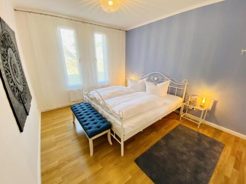 ein Schlafzimmer mit einem weißen Bett und einer blauen Bank in der Unterkunft Residenz/Meeresrauschen in Warnemünde